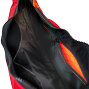 Black interior lining of the crescent shaped crossbody bad with two slip pockets, a zip pocket, and a key leash.