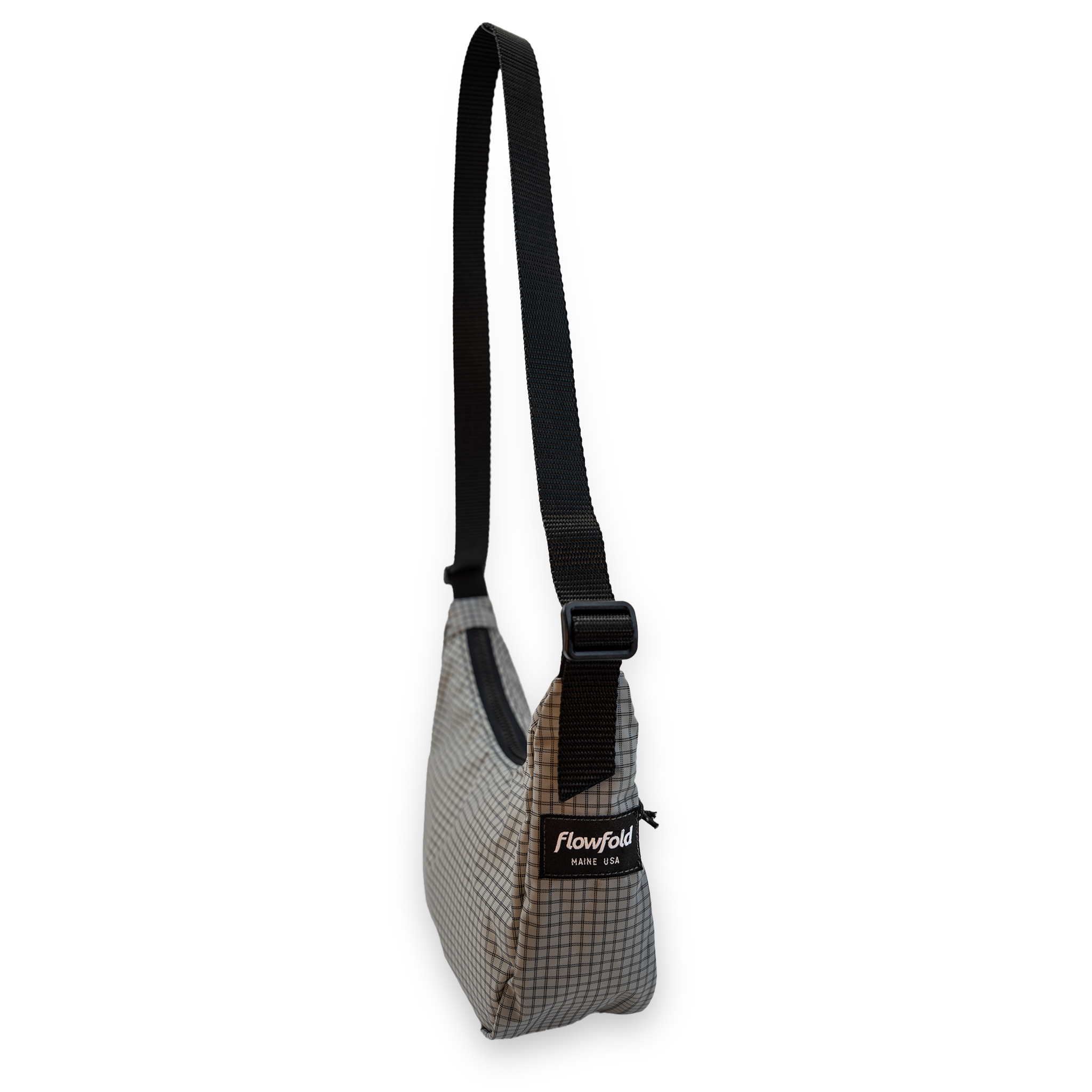 Small gray crossbody bag with a black strap on a white background